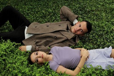 High angle view of couple lying on grass