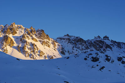 Scenic view of snowcapped mountains against clear blue sky