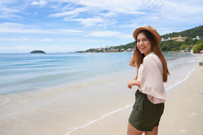 Cheerful stylish traveler woman on jurere beach, florianopolis, santa catarina island, brazil