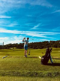 Full length of man standing on golf course against sky