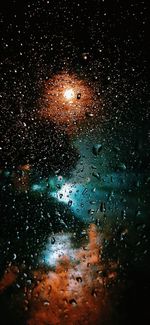 Raindrops on glass window at night