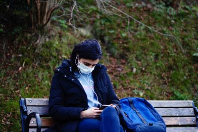 Man sitting on bench in forest