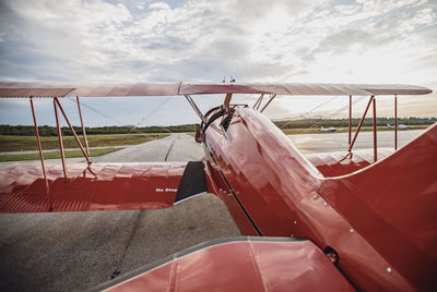 Red shiny restored vintage airplane on airfield at sunrise in maine