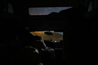 Rear view of silhouette man in car