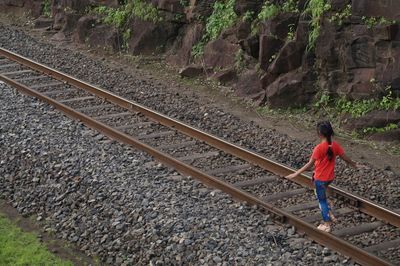 High angle view of girl walking on railroad track