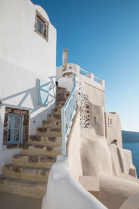 Staircase of building by sea against sky