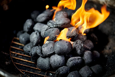 Closeup of glowing coal in metal grill on summer day in the garden