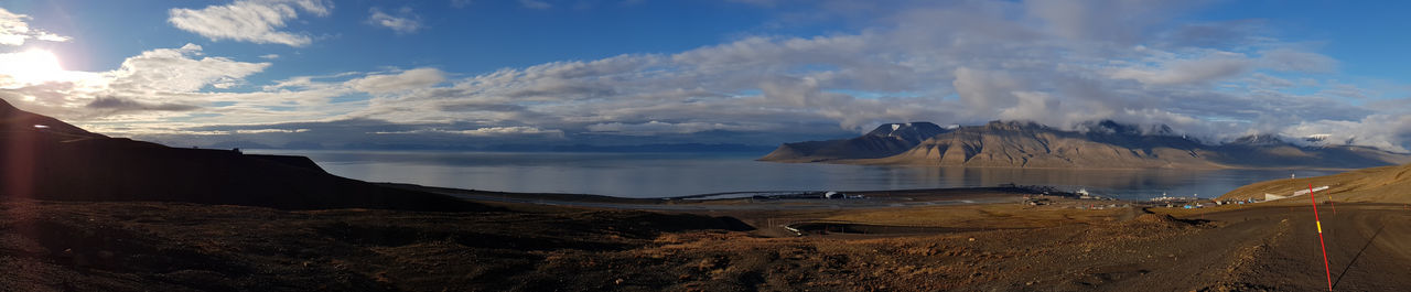 Panoramic view of sea and mountains against sky