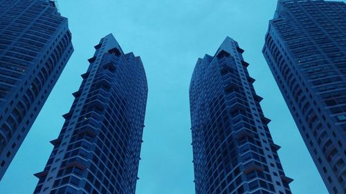 Low angle view of modern buildings against blue sky