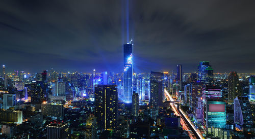 Illuminated city against sky at night