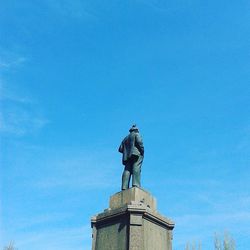 Low angle view of statue against blue sky