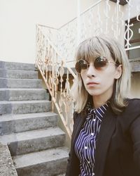 Portrait of woman standing by staircase