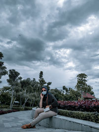 Portrait of woman sitting against sky