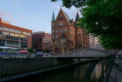 Bridge over river against buildings in city