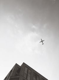 Low angle view of airplane flying against sky