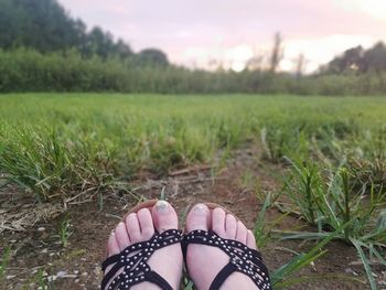 Low section of woman standing on field