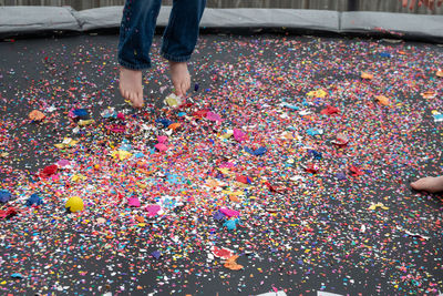Low section of person standing on multi colored umbrella