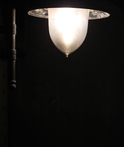 Low angle view of illuminated light bulb against black background