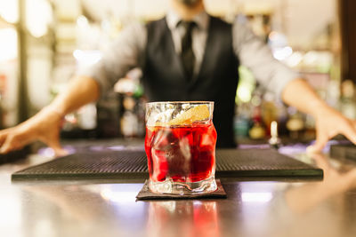 Close-up of cocktail against bartender at bar