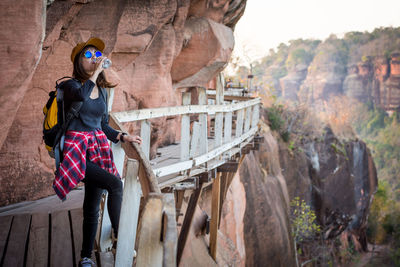 Woman standing on rock by mountain