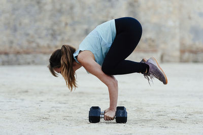 Young woman doing yoga positions in urban environment.