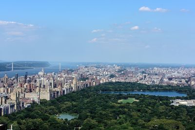 Aerial view of cityscape by sea against sky