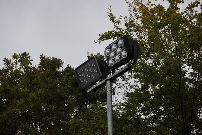 Low angle view of street light by building against sky