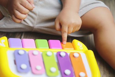 Midsection of child playing with toy piano