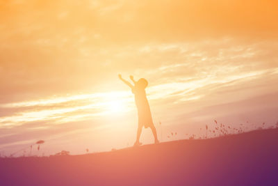 Silhouette woman standing against sky during sunset