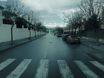 Cars on road against sky during rainy season