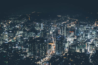 Illuminated cityscape against sky at night