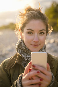 Portrait of confident woman using mobile phone at beach