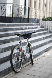 Bicycle parked on footpath by building