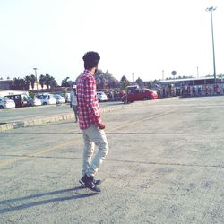 Boy standing on road against clear sky