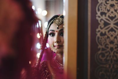 Bride looking at mirror during wedding ceremony