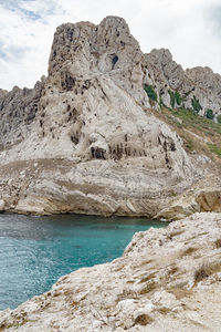 Rock formations by sea against sky