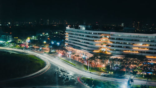 High angle view of illuminated city street and buildings at night