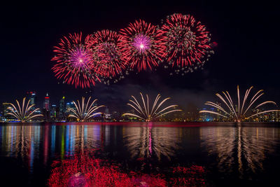 Firework display over river at night