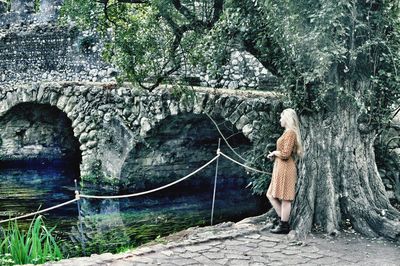 Rear view of woman on bridge over river