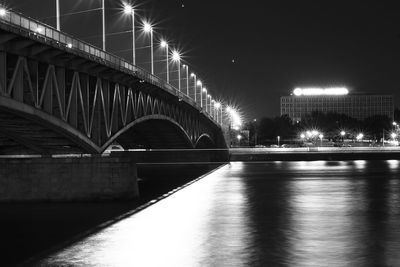 Illuminated bridge over river at night