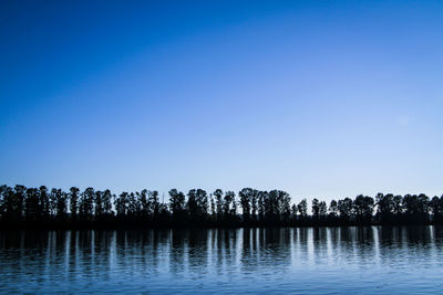Scenic view of lake against clear blue sky