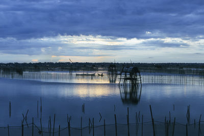 Scenic view of lake against sky at sunset