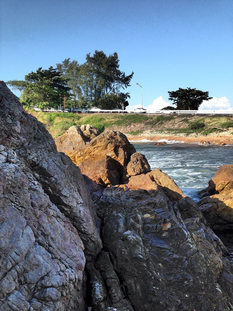 ROCKS BY SEA AGAINST SKY