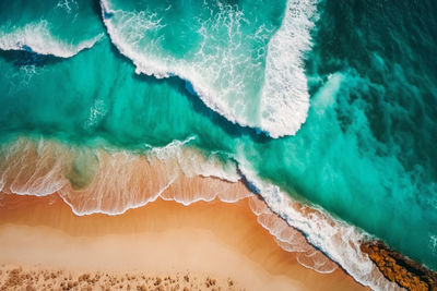 Aerial view of sandy beach and ocean nature with waves.