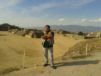 Full length portrait of man standing against landscape and sky