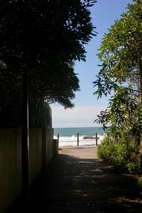 Footpath by sea against sky