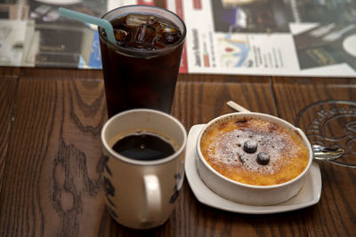 Close-up of pie with coffee and drink on wooden table