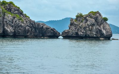 Scenic view of rock formation in sea against sky