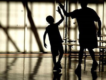 Silhouette of father son giving high-five