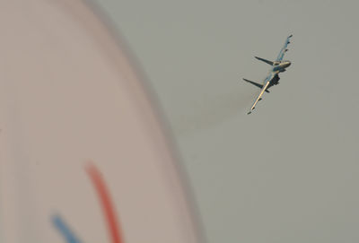 Low angle view of fighter plane flying against clear sky